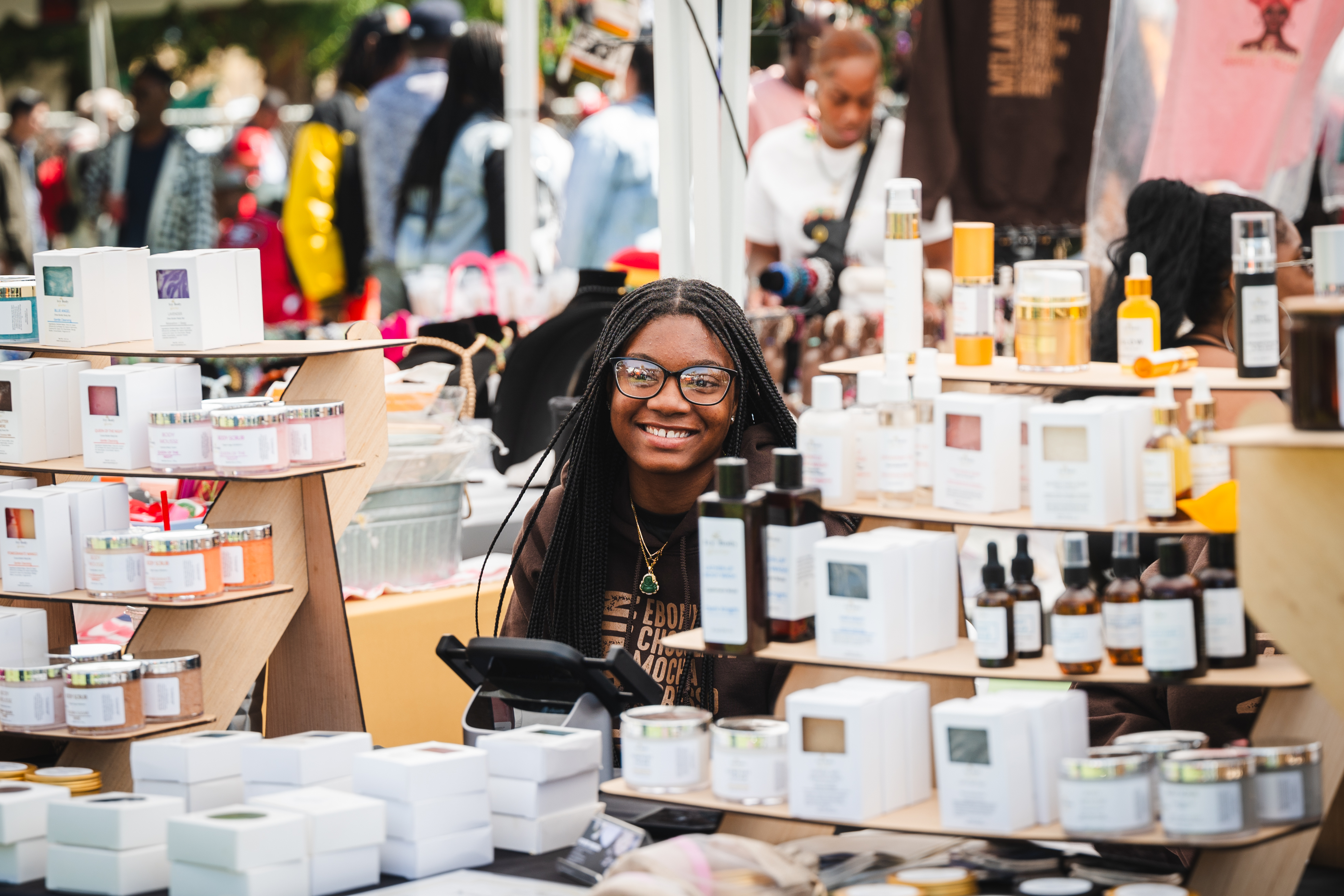 A young Black entrepreneur at a vendor booth during a Black Wall Street activation